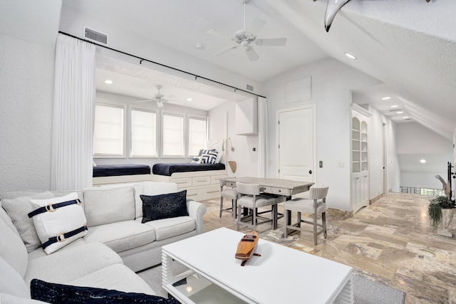 living room with ceiling fan, a textured ceiling, and vaulted ceiling