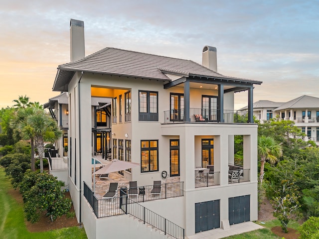 back house at dusk with a balcony