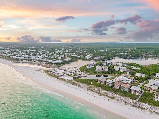 aerial view at dusk with a view of the beach and a water view