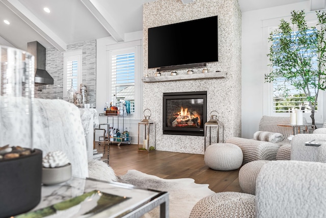 living room with a large fireplace, beam ceiling, and dark hardwood / wood-style flooring