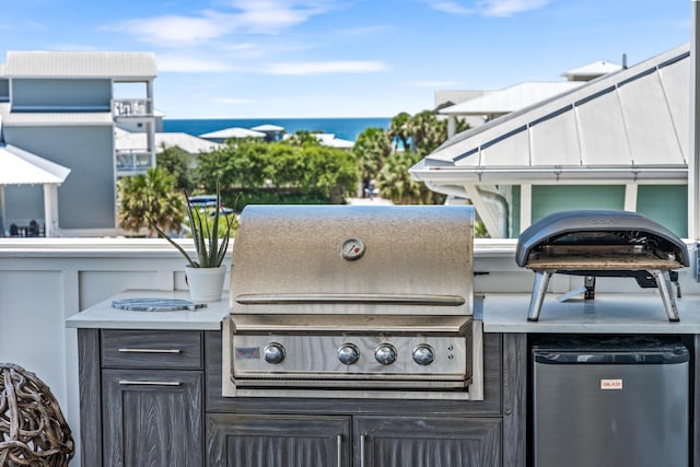 view of patio with area for grilling, an outdoor kitchen, and a water view