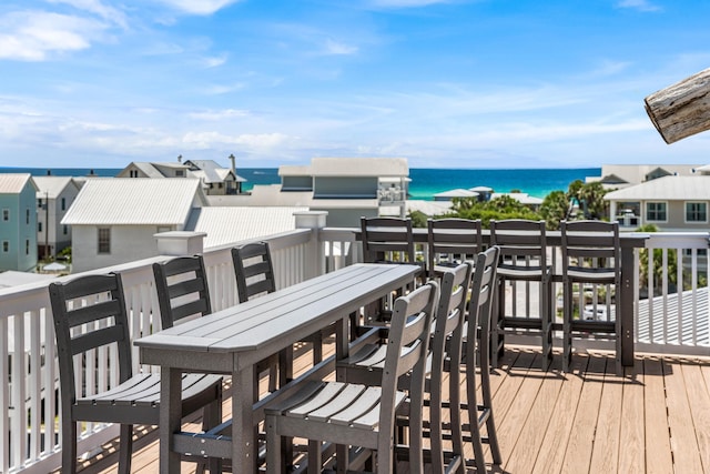 wooden deck featuring a water view and a view of the beach