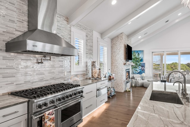 kitchen featuring white cabinetry, double oven range, sink, and wall chimney range hood