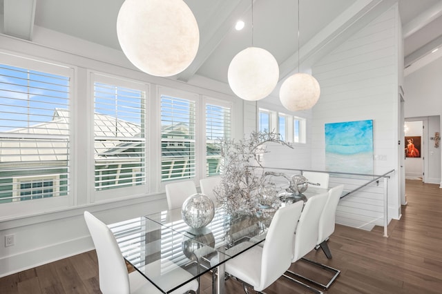 dining area featuring dark wood-type flooring and high vaulted ceiling