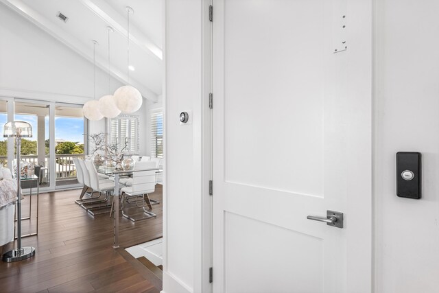 corridor with dark hardwood / wood-style floors and high vaulted ceiling