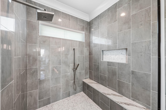 bathroom featuring ornamental molding and a tile shower