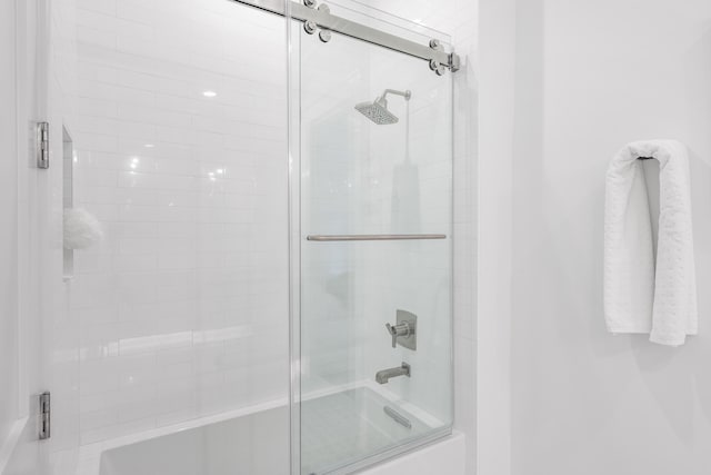 bathroom featuring combined bath / shower with glass door