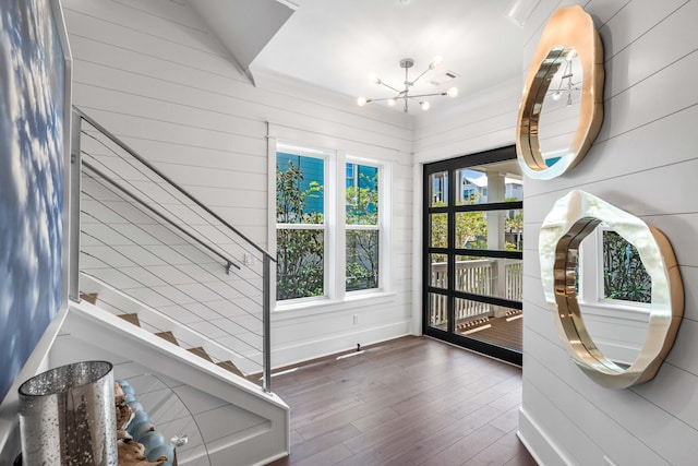 entryway with dark wood-type flooring and a chandelier