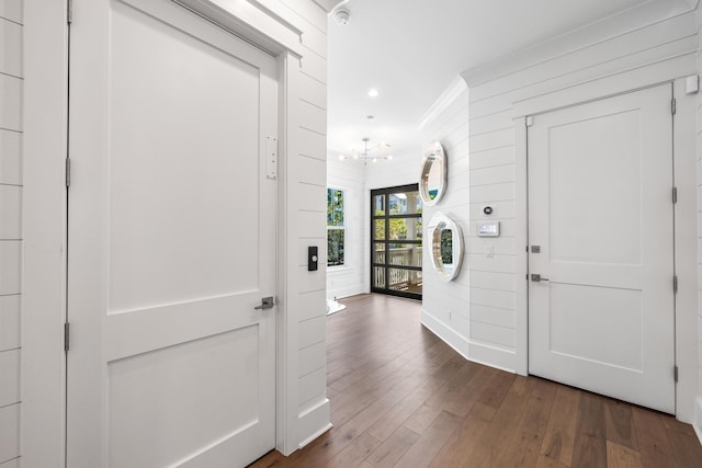 foyer with ornamental molding and dark hardwood / wood-style floors