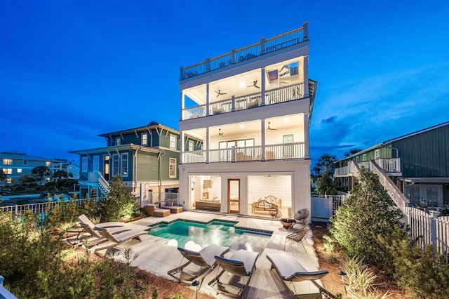 back of house with ceiling fan, a balcony, a fenced in pool, and a patio