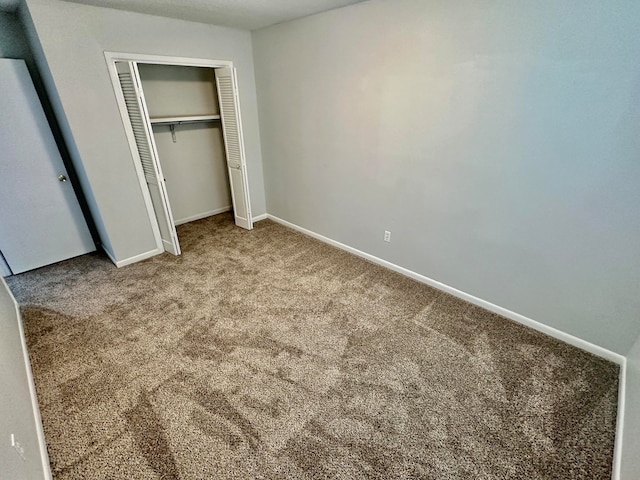 unfurnished bedroom featuring a closet and carpet flooring