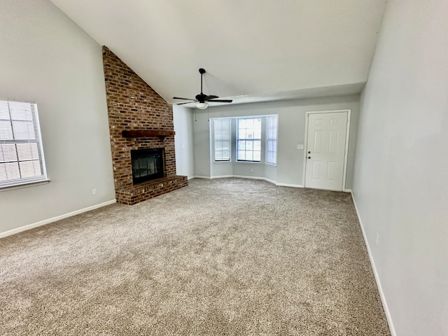 unfurnished living room featuring ceiling fan, brick wall, vaulted ceiling, carpet, and a brick fireplace