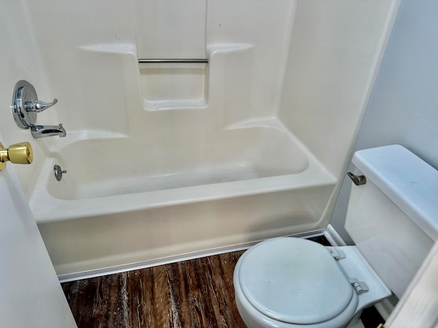 bathroom with tub / shower combination, toilet, and hardwood / wood-style floors