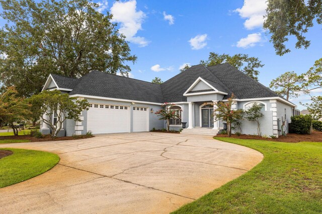 view of front of property featuring a garage and a front lawn