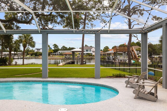 view of swimming pool featuring a yard, a water view, and glass enclosure