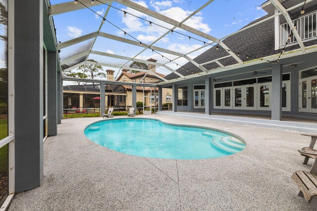 view of pool with a lanai, a patio area, and french doors