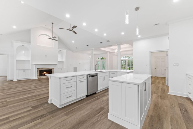 kitchen featuring stainless steel dishwasher, a spacious island, white cabinetry, and light wood-type flooring