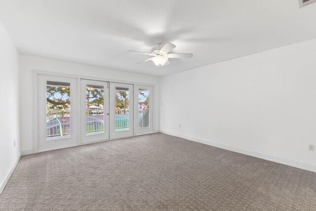 carpeted empty room featuring ceiling fan and french doors