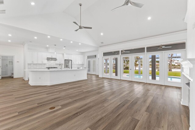 unfurnished living room featuring french doors, high vaulted ceiling, dark wood-type flooring, and sink