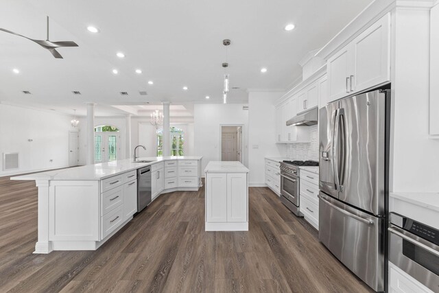 kitchen with a large island, white cabinetry, stainless steel appliances, and decorative light fixtures