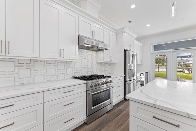 kitchen featuring tasteful backsplash, light stone counters, stainless steel appliances, crown molding, and white cabinetry