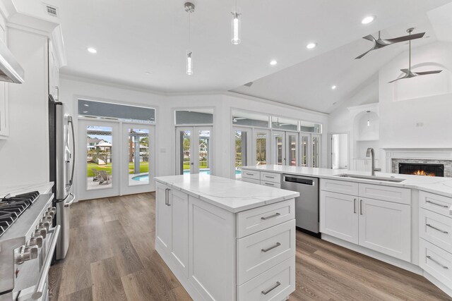 kitchen featuring white cabinetry, sink, stainless steel appliances, and decorative light fixtures