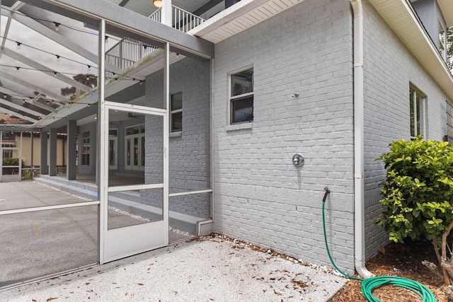 view of side of property with a patio area and a sunroom