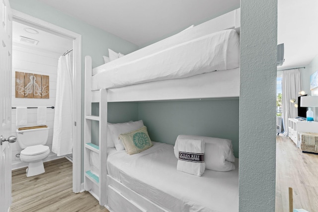 bedroom featuring light hardwood / wood-style floors and connected bathroom