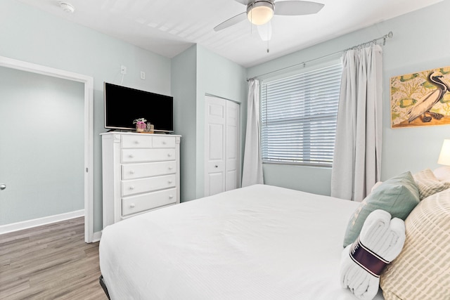 bedroom featuring ceiling fan, light hardwood / wood-style floors, and a closet