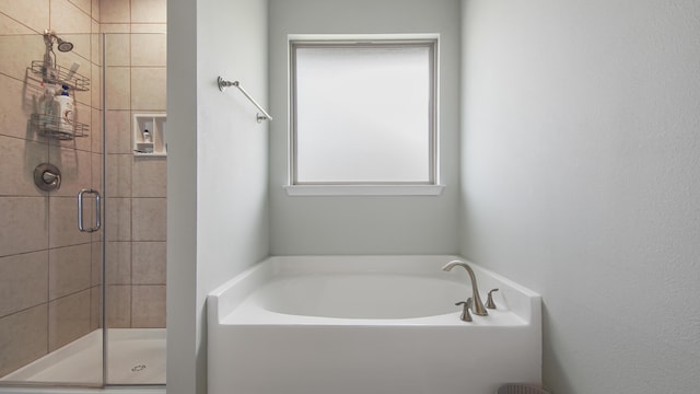 bathroom featuring shower with separate bathtub