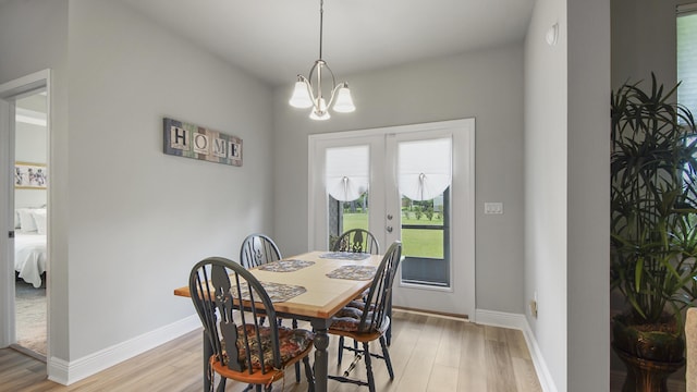 dining space featuring light hardwood / wood-style flooring, french doors, and a chandelier