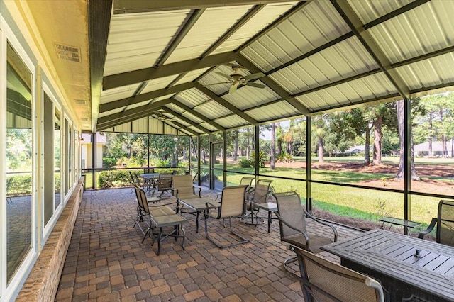 unfurnished sunroom featuring ceiling fan and lofted ceiling