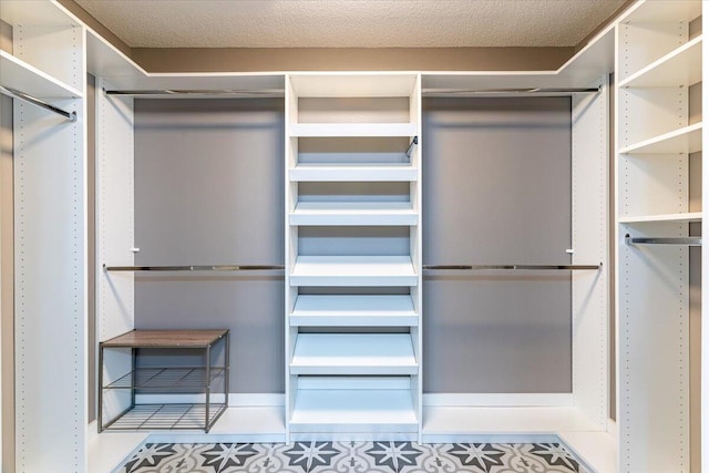 walk in closet with light tile patterned floors