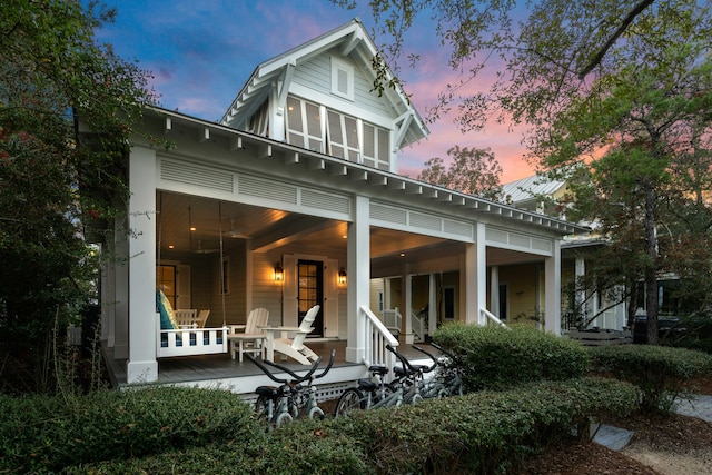 back house at dusk with covered porch