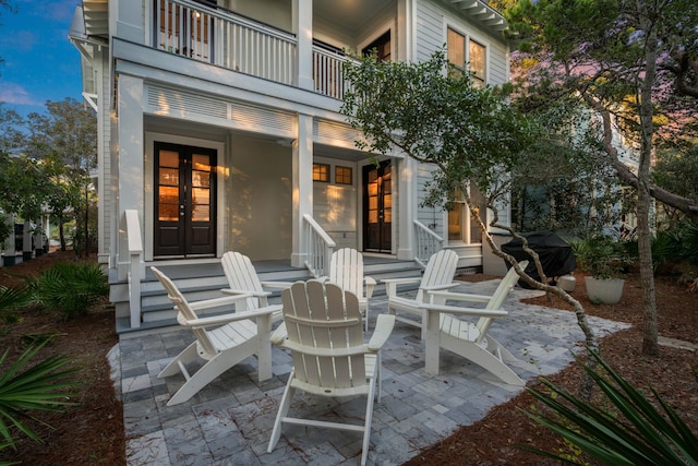 view of patio / terrace with a grill, french doors, and a balcony