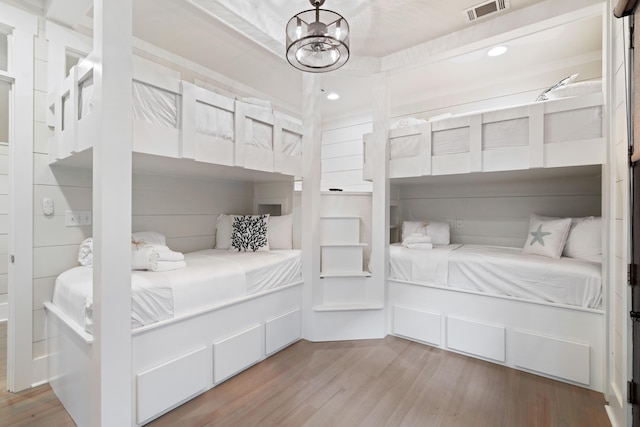 bedroom featuring an inviting chandelier and hardwood / wood-style floors