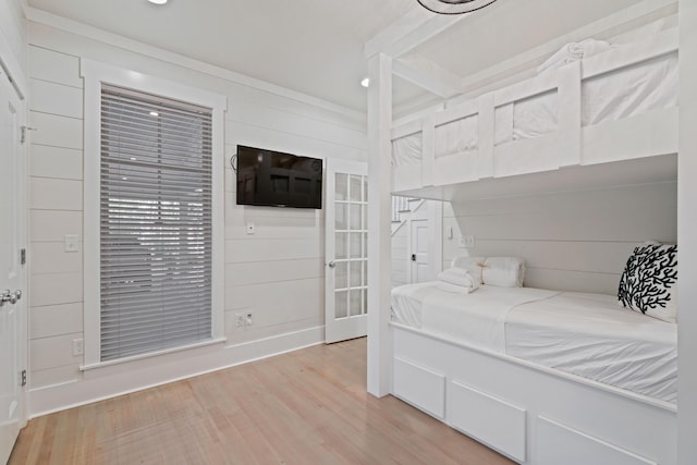 bedroom featuring wood walls and light wood-type flooring