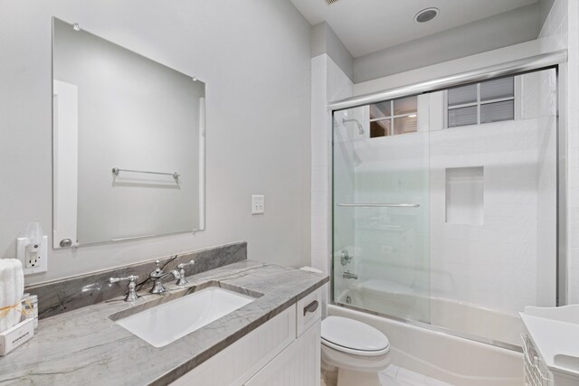 full bathroom with vanity, combined bath / shower with glass door, and toilet