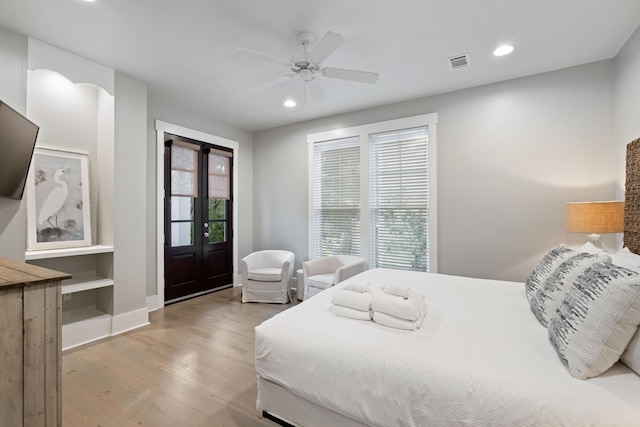 bedroom featuring ceiling fan, light hardwood / wood-style floors, multiple windows, and access to outside