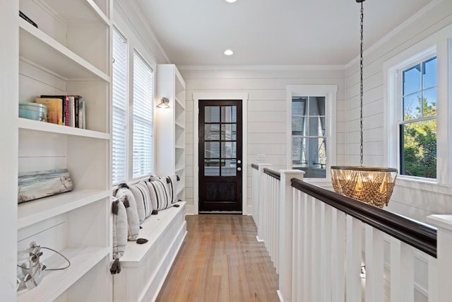 mudroom featuring crown molding, a healthy amount of sunlight, a notable chandelier, and light wood-type flooring