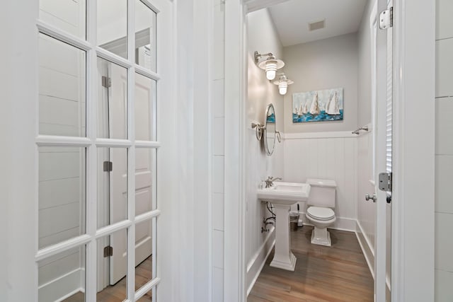 bathroom with hardwood / wood-style flooring and toilet