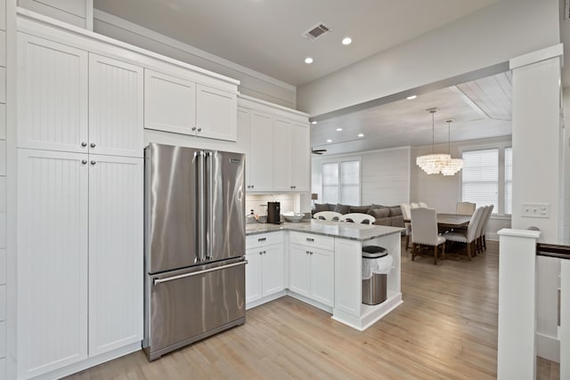 kitchen featuring white cabinetry, hanging light fixtures, high quality fridge, light hardwood / wood-style floors, and stone countertops