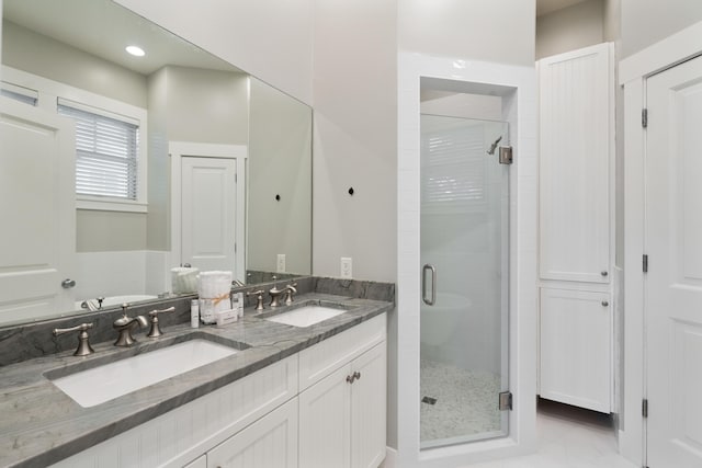 bathroom with vanity and a shower with door