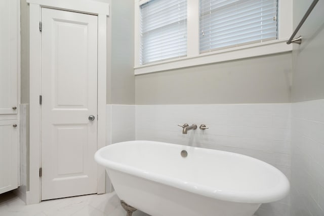 bathroom with tile walls and a tub