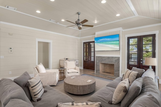 living room featuring french doors, wood ceiling, crown molding, vaulted ceiling, and a premium fireplace