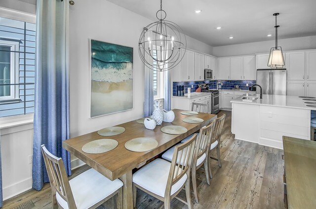 dining room featuring an inviting chandelier, sink, and hardwood / wood-style floors