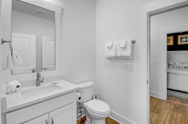 bathroom featuring hardwood / wood-style flooring, toilet, and vanity