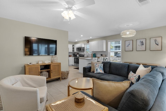 tiled living room featuring sink and ceiling fan