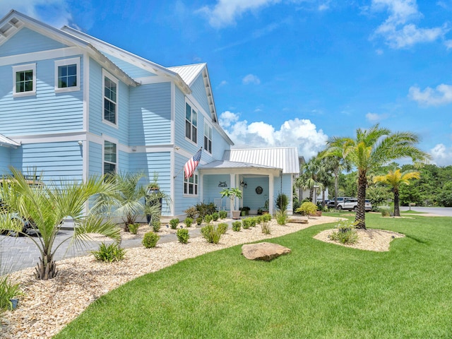 61 Sweet Breeze Dr, Santa Rosa Beach, FL 32459 - view of home's exterior featuring a lawn, metal roof, and a porch