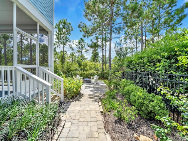 61 Sweet Breeze Dr, Santa Rosa Beach, FL 32459 - view of yard featuring a fire pit, fence, a patio area, and view of scattered trees